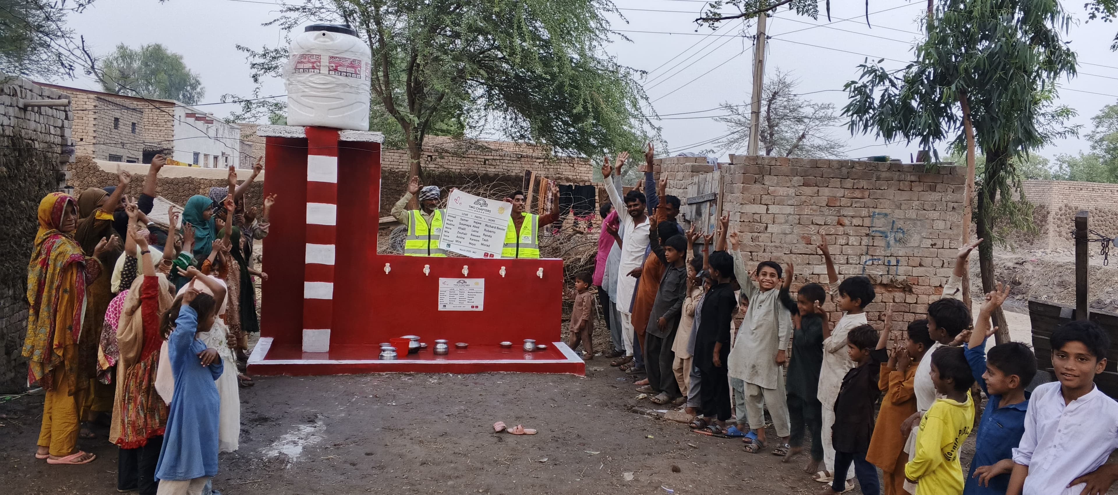 Families and children gathered at a water well built through the TwoChaptersAhead partnership