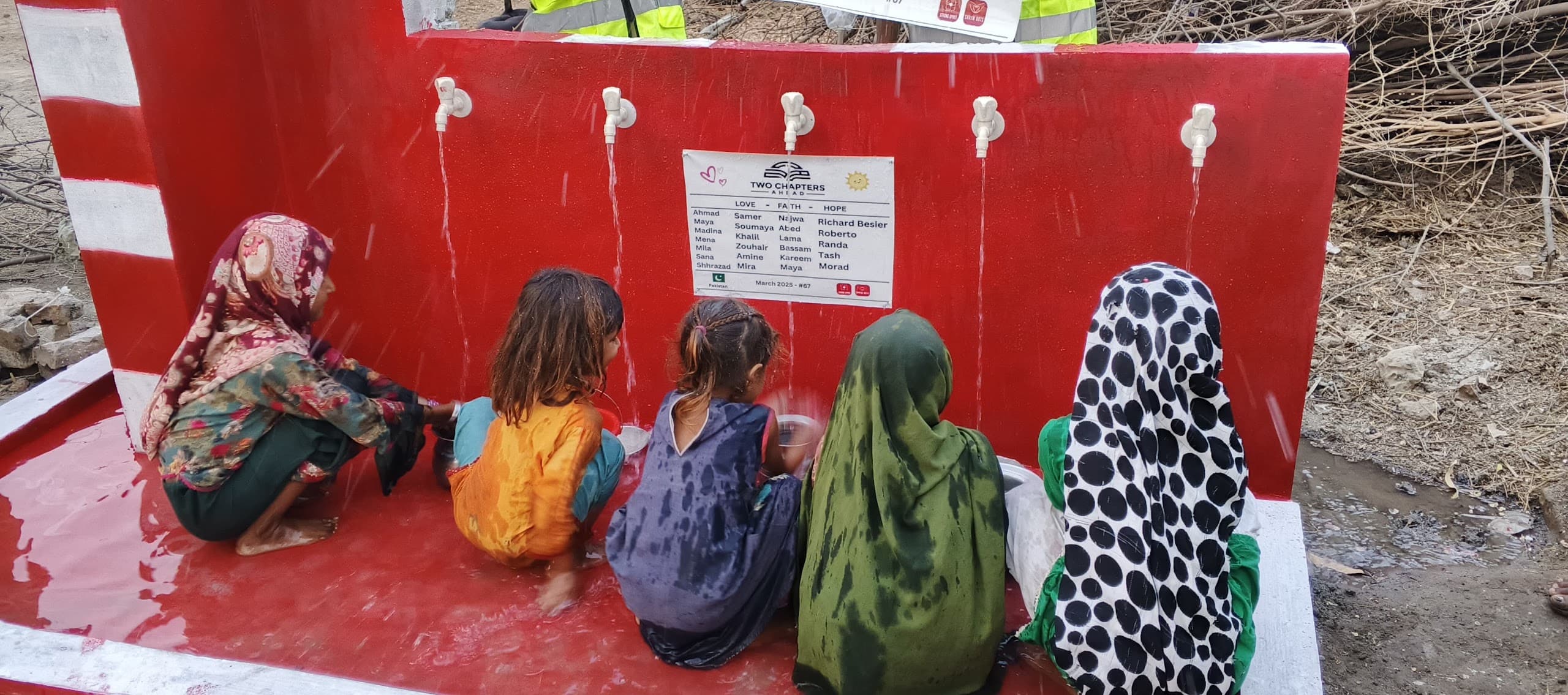 Women and children collecting water at a well from the TwoChaptersAhead partnership